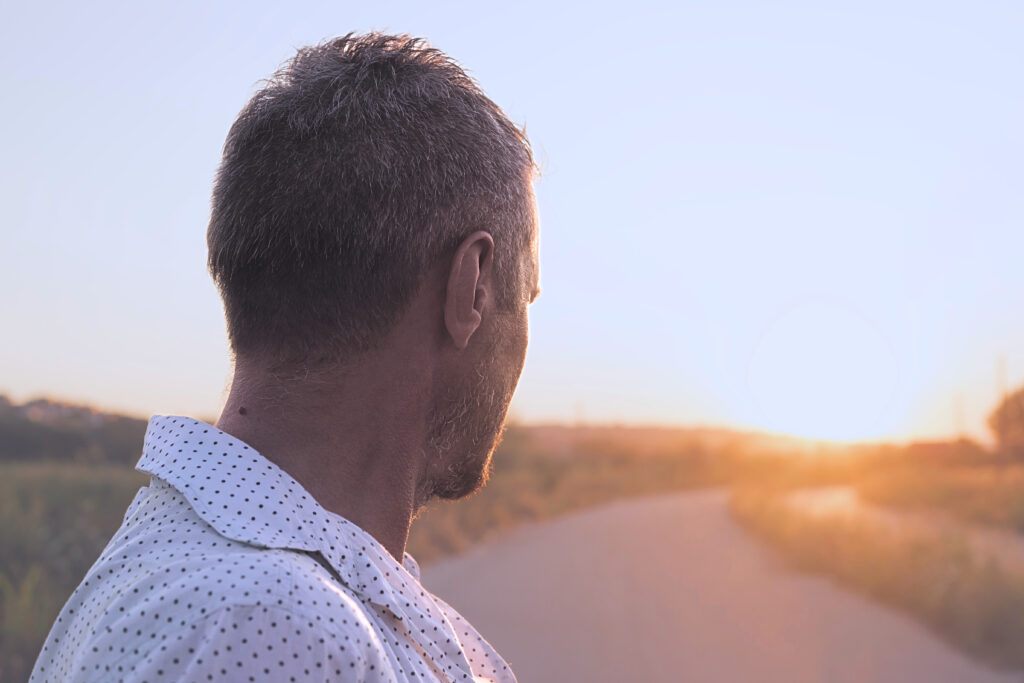 Mann schaut auf einen Weg vor sich